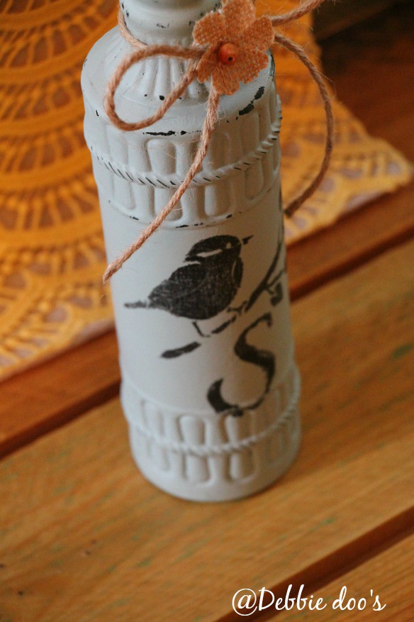 Stenciled bird and monogram on a bottle